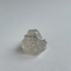 scs recycled sterling silver stacking band with granulation details on a crystal quartz on white backgraound handcrafted 