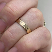 Load image into Gallery viewer, Image of a 4mm hammered finish yellow gold wedding band with a freestyle hammered texture. The band is made with recycled ethical solid 10kt, 14kt, or 18kt yellow gold and is stamped with its karat weight and hallmarked. Available in a range of sizes and made to order, shipping includes tracking within Canada and the United States, and internationally. The ring comes gift-wrapped, making it a special and meaningful present

