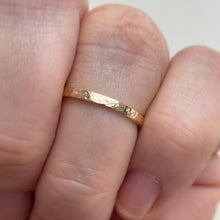 Load image into Gallery viewer, Image of a handcrafted thin 2mm hammered finish yellow gold wedding band with a freestyle hammered texture. The band is ethically sourced and made using recycled 10kt, 14kt, or 18kt yellow gold. The band is stamped with its karat weight and hallmarked. Available in various sizes and made to order, shipping includes tracking within Canada and the United States, and internationally
