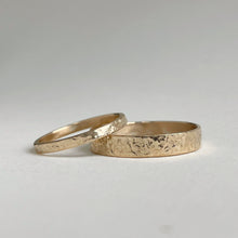Load image into Gallery viewer, Image of a handcrafted thin 2mm hammered finish yellow gold wedding band with a freestyle hammered texture. The band is ethically sourced and made using recycled 10kt, 14kt, or 18kt yellow gold. The band is stamped with its karat weight and hallmarked. Available in various sizes and made to order, shipping includes tracking within Canada and the United States, and internationally
