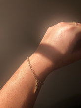 Load image into Gallery viewer, Solid gold charm bracelet with a fine link chain and a rustic texture, crafted by hand with ethically sourced and recycled 10kt yellow gold. Comes with an adjustable clasp and lobster clasp, and a tag with a metal stamp and makers mark.