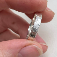 Load image into Gallery viewer, Textured hammered Sterling Silver wedding band with a rustic and unique design, available in a range of sizes, and gift-wrapped. Measures 4mm in width and 1.25mm in thickness. Perfect as a sustainable and eco-friendly wedding band with a personal touch.