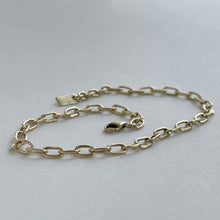 Load image into Gallery viewer, Solid gold charm bracelet with a fine link chain and a rustic texture, crafted by hand with ethically sourced and recycled 10kt yellow gold. Comes with an adjustable clasp and lobster clasp, and a tag with a metal stamp and makers mark.