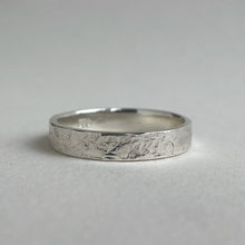 Load image into Gallery viewer, Textured hammered Sterling Silver wedding band with a rustic and unique design, available in a range of sizes, and gift-wrapped. Measures 4mm in width and 1.25mm in thickness. Perfect as a sustainable and eco-friendly wedding band with a personal touch.