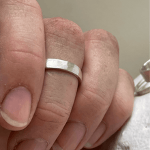Load image into Gallery viewer, Brushed hammered wedding ring on a hand
