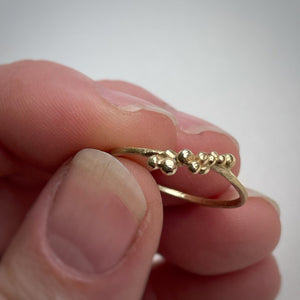 granulated yellow gold stacking ring size 8 in hand on white background  ooak handcrafted ethically made