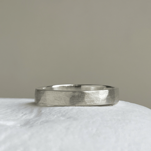 Close-up of the freestyle hammered texture on the brushed textured wedding band