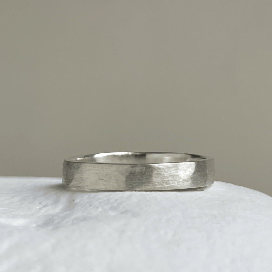 Close-up of the freestyle hammered texture on the brushed textured wedding band