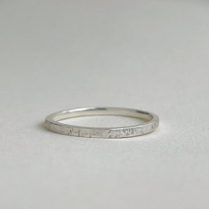Thin hammered Sterling Silver wedding band with a freestyle texture, available in a range of sizes, and gift-wrapped. Measures 1.5mm in width and 1.25mm in thickness. Perfect as a minimal and unique wedding ring for her.