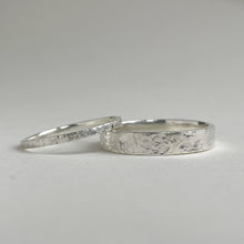 Load image into Gallery viewer, Textured hammered Sterling Silver wedding band with a rustic and unique design, available in a range of sizes, and gift-wrapped. Measures 4mm in width and 1.25mm in thickness. Perfect as a sustainable and eco-friendly wedding band with a personal touch.
